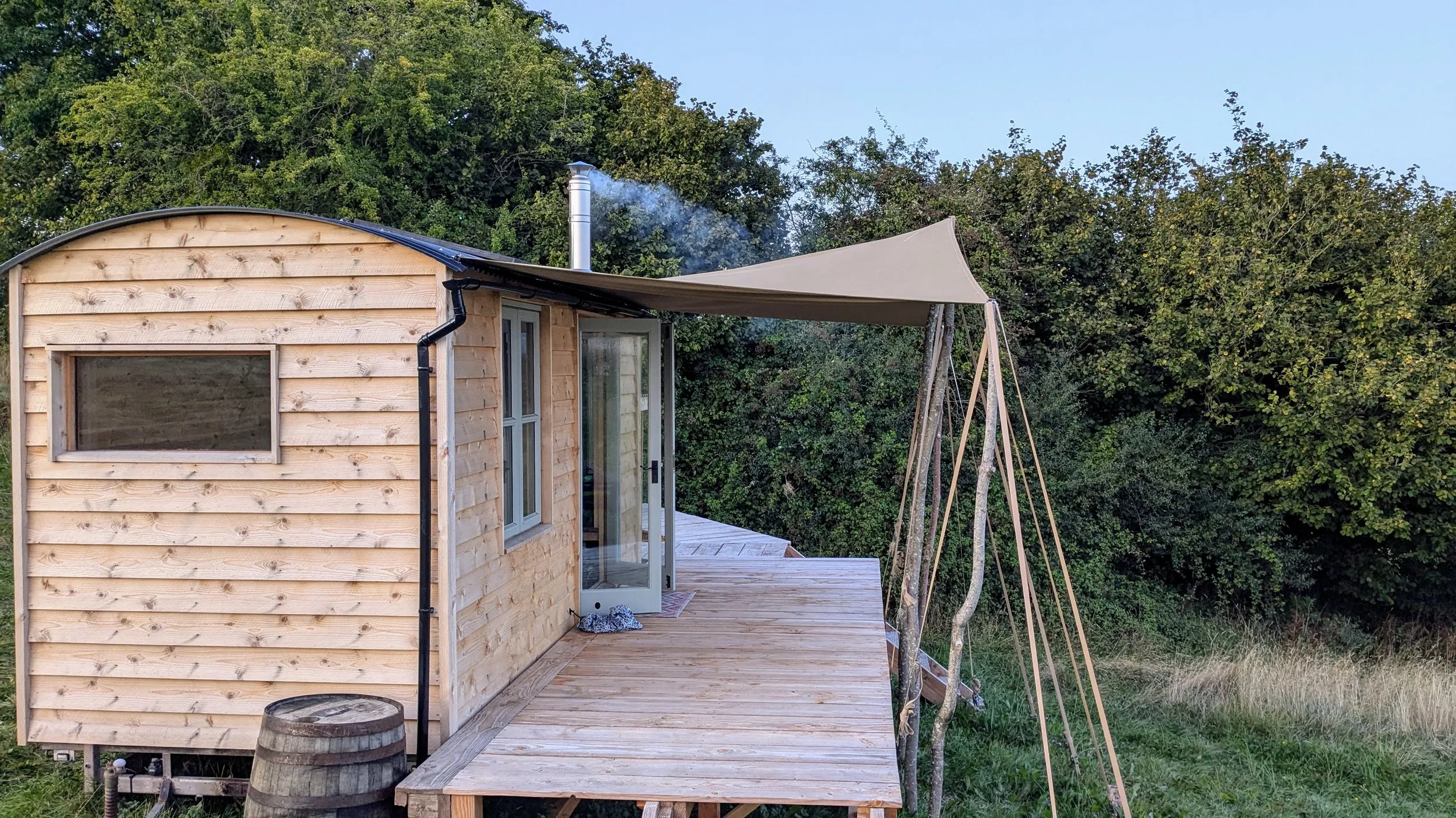 Sunset view from off-grid cabin deck overlooking rewilded landscape
